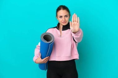 Ukraynalı kadın elinde minder tutarak yoga derslerine gidiyor.