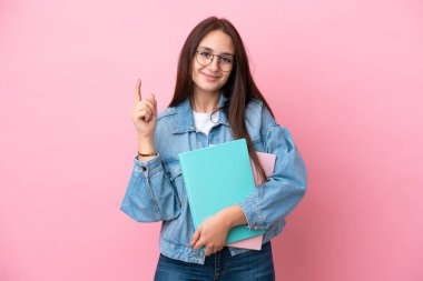 Pembe arka planda izole edilmiş genç Ukraynalı kadın en iyinin işareti olarak parmağını kaldırıyor.