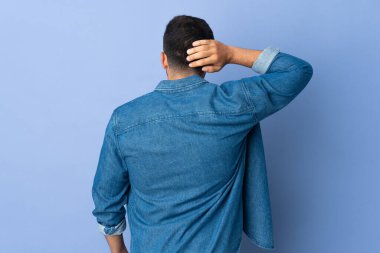 Kafkasyalı adam arka planda mavi arka planda ve düşünüyor.