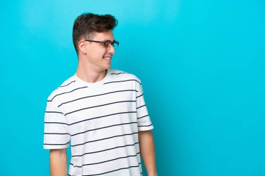 Mavi arka planda izole edilmiş yakışıklı Brezilyalı bir adam.