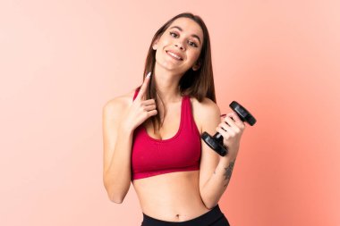 Genç sporcu kadın halter yapıyor izole edilmiş pembe arka plan üzerinde ağız açık bağırarak