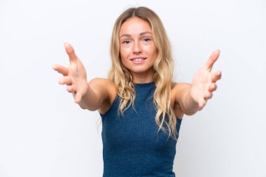 Beyaz arka planda izole edilmiş genç bir Rus kadın sunuyor ve davet ediyor.