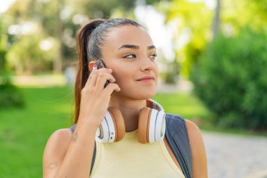 Dışarıda cep telefonu kullanan genç ve güzel bir kadın.