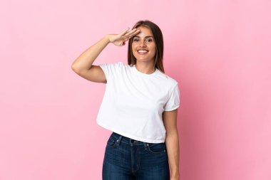 Genç Uruguaylı kadın pembe arka planda izole edilmiş, mutlu bir ifadeyle selamlanıyor.