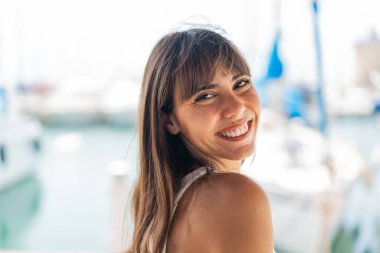 Açık havada genç bir kadın Neşeli bir ifadeyle