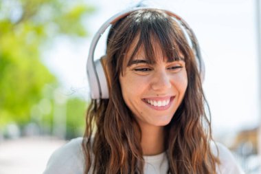 Açık havada müzik dinleyen genç bir kadın