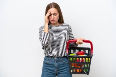Genç Romen kadın elinde yiyecek dolu bir sepet tutuyor beyaz arka planda izole edilmiş baş ağrısıyla