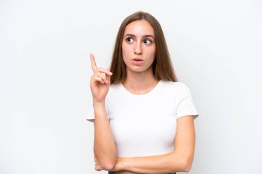 Beyaz arka planda izole edilmiş genç beyaz bir kadın, bir fikrin suçluyu işaret ettiğini düşünüyor.
