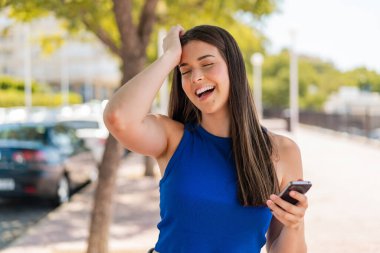Dışarıda cep telefonu kullanan genç ve güzel Brezilyalı kadın bir şey fark etti ve çözümü arıyor.