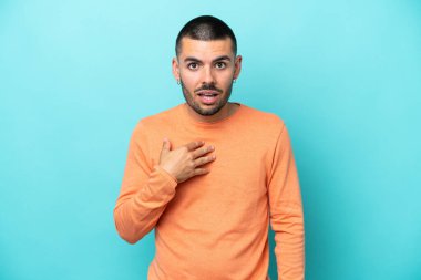 Mavi arka planda izole edilmiş genç beyaz adam kendini işaret ediyor.