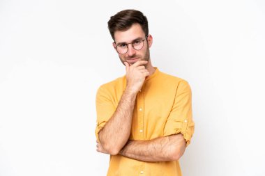 Beyaz arka planda izole edilmiş genç beyaz adam mutlu ve gülümsüyor.