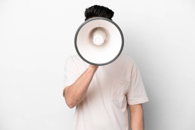 Beyaz arka planda izole edilmiş genç beyaz bir adam megafondan bir şey duyurmak için bağırıyor.