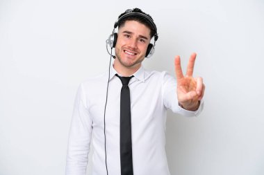 Beyaz arka planda izole edilmiş beyaz pazarlamacı. Gülümsüyor ve zafer işareti gösteriyor.