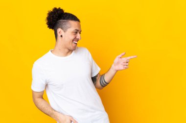 İzole edilmiş arka planda beyaz bir adam parmak işareti yapıyor ve bir ürün sunuyor.