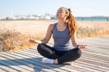 Yoga yapan genç ve güzel bir bayan.