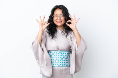 Kimono giyen genç Asyalı kadın beyaz arka planda izole edilmiş. Parmaklarıyla 