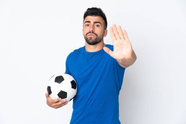 Yakışıklı genç futbolcu, izole olmuş duvardan atlayıp durma hareketi yapıyor.