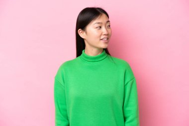 Pembe arka planda izole edilmiş genç bir Çinli kadın.