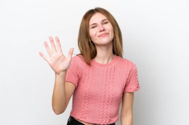 Beyaz arka planda izole edilmiş genç İngiliz kadın parmaklarıyla beşi sayıyor