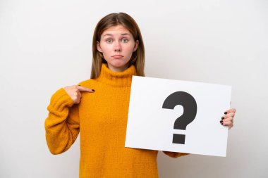 Beyaz arka planda izole edilmiş genç bir İngiliz kadın elinde soru işareti sembolü ve şaşırmış ifade içeren bir pankart tutuyor.