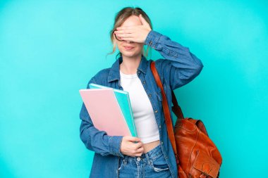 Mavi arka planda, gözleri elleriyle kapatan genç bir kız öğrenci. Bir şey görmek istemiyorum.