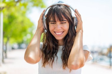 Açık havada müzik dinleyen genç bir kadın