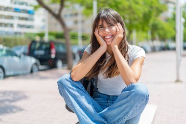 Açık havada genç bir kadın Neşeli bir ifadeyle