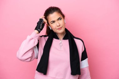 Pembe arka planda izole edilmiş Brezilyalı genç bir kadının şüpheleri ve kafası karışmış bir yüz ifadesi var.