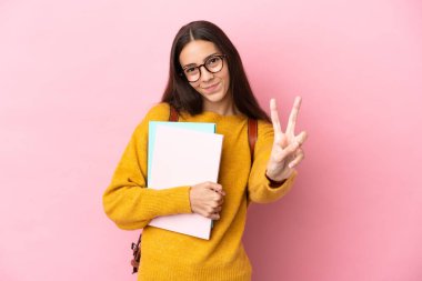 Tecrit edilmiş genç bayan öğrenci gülümsüyor ve zafer işareti gösteriyor.