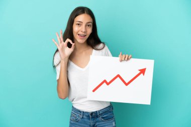 Mavi arka planda izole edilmiş genç bir Fransız kadın elinde büyüyen bir istatistik oku sembolü ve 