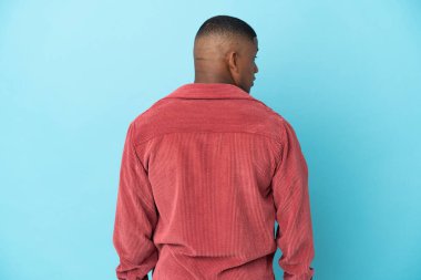 Genç latin adam mavi arka planda izole edilmiş.