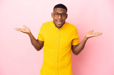 Pembe arka planda izole edilmiş genç latin adam şok olmuş yüz ifadesi ile