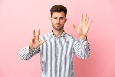 Pembe arka planda izole edilmiş beyaz tenli yakışıklı sekiz parmaklı adam.