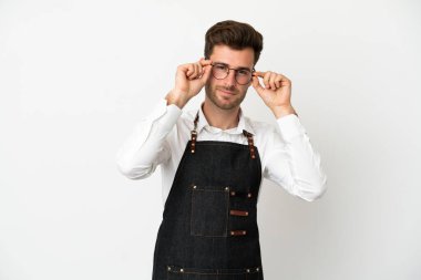 Kafkasyalı garson beyaz arka planda gözlüklü ve şaşırmış.