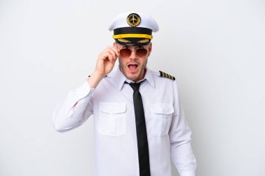 Kafkasyalı uçak pilotu beyaz arka planda gözlüklü ve şaşırmış.