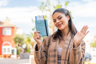 Pasaportunu tutan genç ve güzel bir kadın. Mutlu bir ifadeyle selamlıyor.