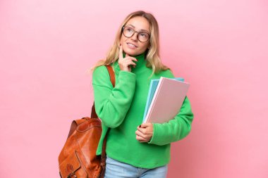 Pembe arka planda izole edilmiş genç bir kadın.