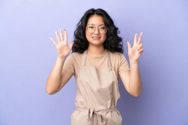 Restoran Asyalı garson mor arka planda izole edilmiş, parmaklarıyla sekiz kişi sayıyor.