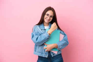 Pembe arka planda izole edilmiş genç Ukraynalı kadın bir zaferi kutluyor.