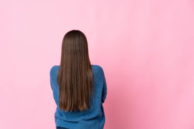 Genç Uruguaylı kadın arka planda pembe arka planda izole edilmiş.