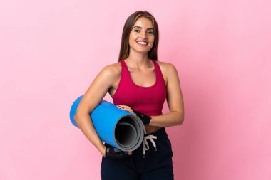 Genç Uruguaylı kadın pembe arka planda bir paspas ile izole edilmiş ve gülümsüyor.