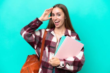 Young student caucasian woman isolated on blue background with surprise expression