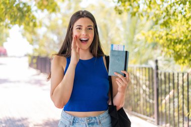 Dışarıda pasaport tutan genç, güzel Brezilyalı kadın ağzı açık bağırıyor.