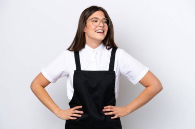 Brezilyalı garson kadın beyaz arka planda izole edilmiş, kolları kalçasında ve gülümsüyor.
