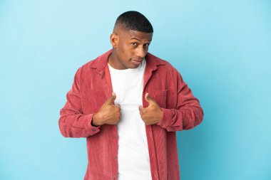 Mavi arka planda izole edilmiş genç latin adam kendini gösteriyor.