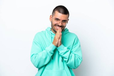 Beyaz arka planda izole genç beyaz adam avuç içlerini bir arada tutuyor. İnsan bir şey ister.