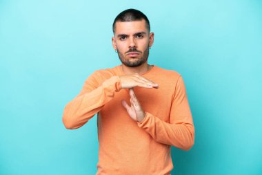 Kafkasyalı genç adam mavi arka planda izole edilmiş.