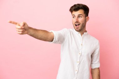 Pembe arka planda izole edilmiş beyaz, yakışıklı bir adam.