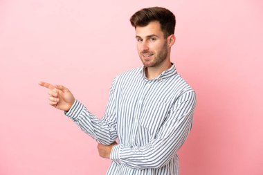 Pembe arka planda izole edilmiş beyaz, yakışıklı genç bir adam.