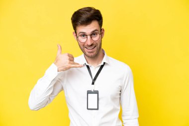 Sarı arka planda izole edilmiş, telefon hareketi yapan beyaz bir genç. Bana geri dönüş işareti ver.